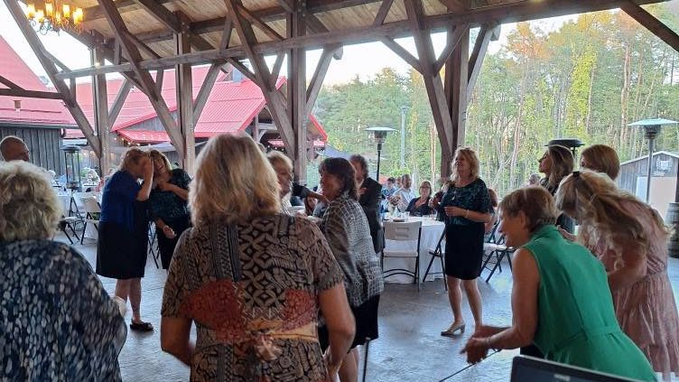Guests mingle at a wedding reception BillyO DJed in a timber-frame pavilion